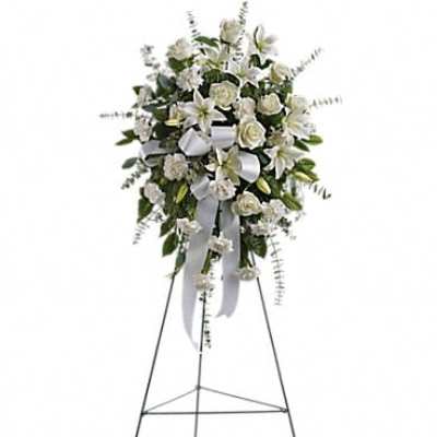 White funeral spray on a standing easel with ribbon