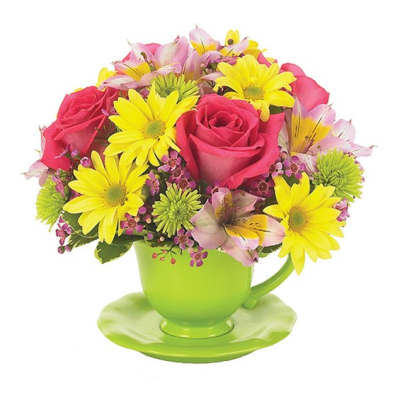Pink roses and yellow daisies in a green teacup vase
