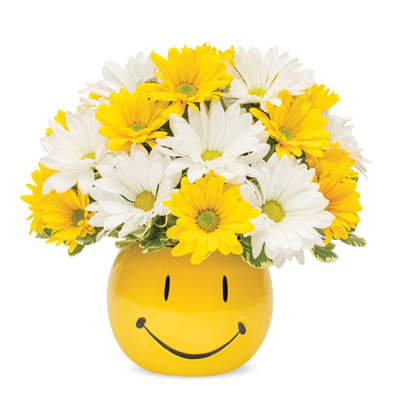 Yellow and white daisies in a smiley-face vase