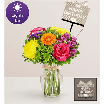 Mixed bouquet in a glass vase with a birthday sign