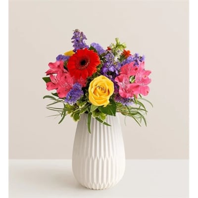 Colorful bouquet in a white vase with a red gerbera and yellow rose