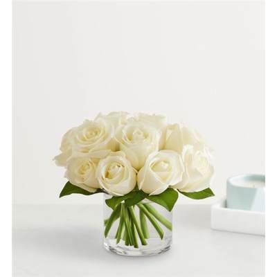 White roses arranged in a clear glass vase