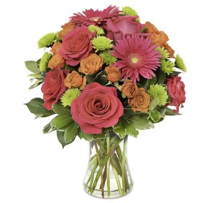 Bouquet of pink roses, orange spray roses, and pink gerbera daisies in a clear glass vase