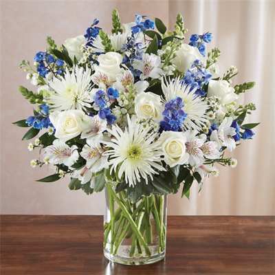 White and blue mixed bouquet in a clear glass vase