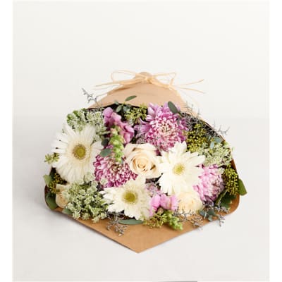 Mixed bouquet of white and pink flowers wrapped in brown paper