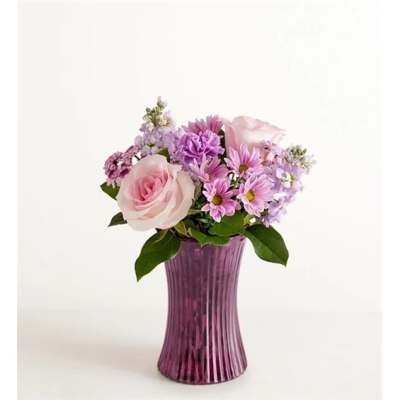 Pink and lavender flowers arranged in a purple vase