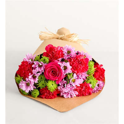 Bouquet of pink, red, and green flowers wrapped in brown paper