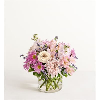 Pink and white mixed flowers arranged in a clear glass vase