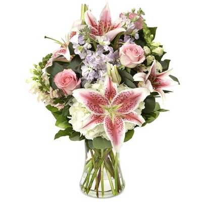 Pink lilies and roses in a clear glass vase