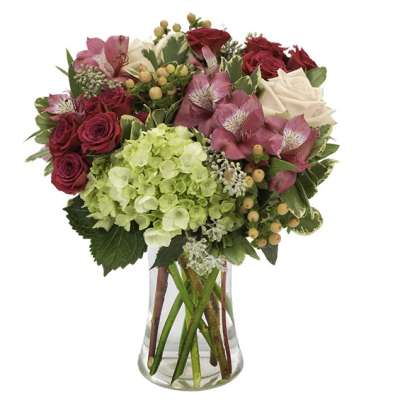 Mixed bouquet of pink and white flowers in a clear glass vase