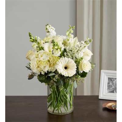 White floral arrangement in a clear glass vase on a table