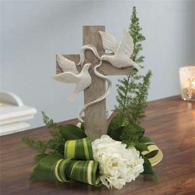 White flowers and a wooden cross with dove decorations