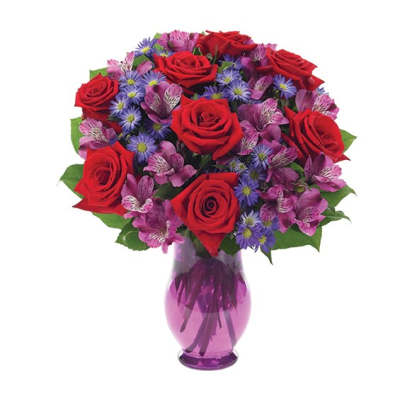 Bouquet of red roses and purple mixed flowers in a purple glass vase