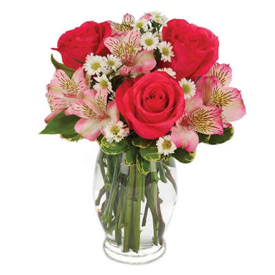 Bouquet of red roses, pink alstroemeria, and white daisies in a clear glass vase