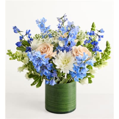 Blue and white flower arrangement in a green vase