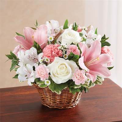 Pink lilies and white roses in a wicker basket