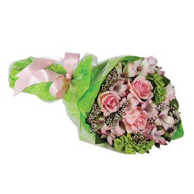 Pink roses and mixed blooms wrapped in green paper with a pink ribbon