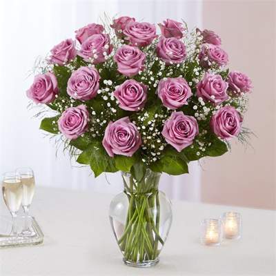 Pink rose bouquet in a clear glass vase with baby's breath