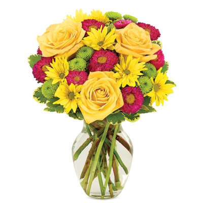 Yellow roses and mixed daisies in a clear glass vase