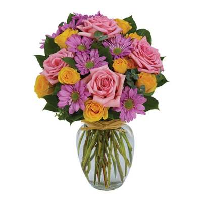 Bouquet of pink roses, purple daisies, and yellow roses in a glass vase