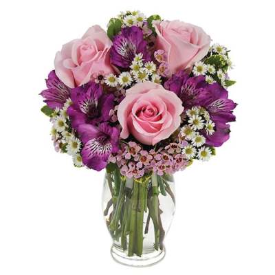 Pink roses and purple alstroemeria in a clear glass vase