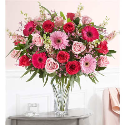 Pink and red rose bouquet with gerbera daisies in a clear glass vase
