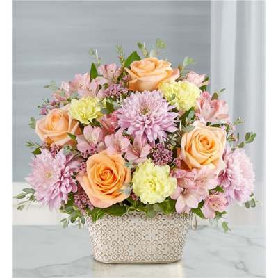 Pastel flower arrangement in a patterned ceramic container