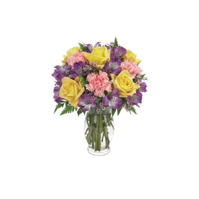 Yellow roses and purple flowers arranged in a clear glass vase