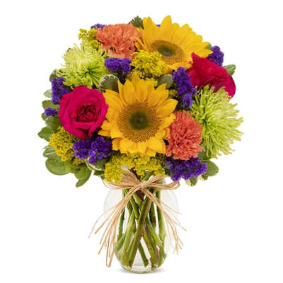 Mixed bouquet of sunflowers, roses, and carnations in a glass vase