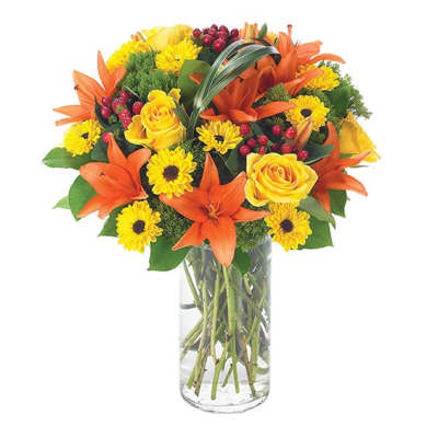 Bouquet of orange lilies and yellow roses in a clear glass vase