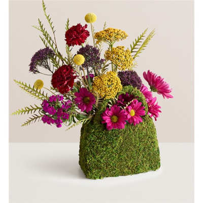 Bright mixed flowers arranged in a moss-covered cube container