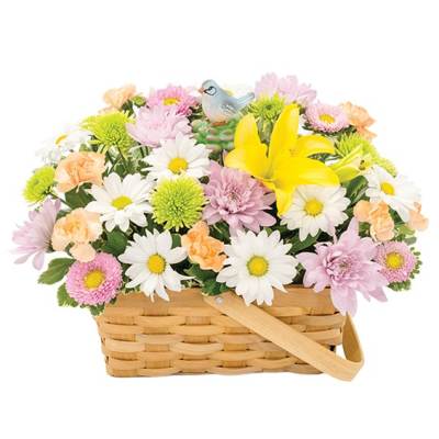 Basket of pastel flowers with a small bird figurine