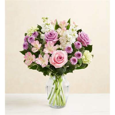 Pink and lavender flowers arranged in a clear glass vase