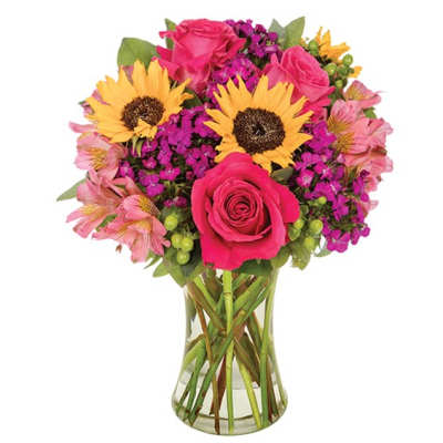 Bouquet of pink roses and yellow sunflowers in a clear glass vase