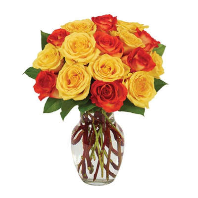Bouquet of yellow and red roses in a clear glass vase
