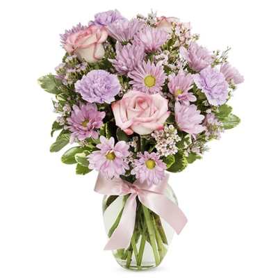 Pink roses and daisies in a clear glass vase with a pink ribbon