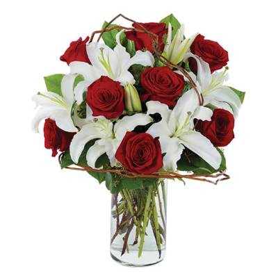 Red roses and white lilies arranged in a clear glass vase