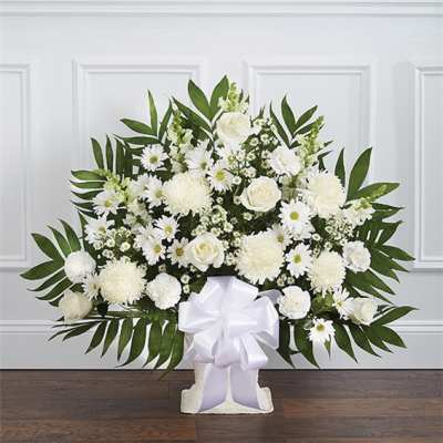 White floral arrangement with daisies and roses in a pedestal vase