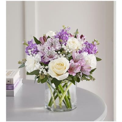 Bouquet of white and purple flowers in a clear glass vase