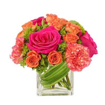 Bouquet of pink and orange roses and carnations in a clear glass vase