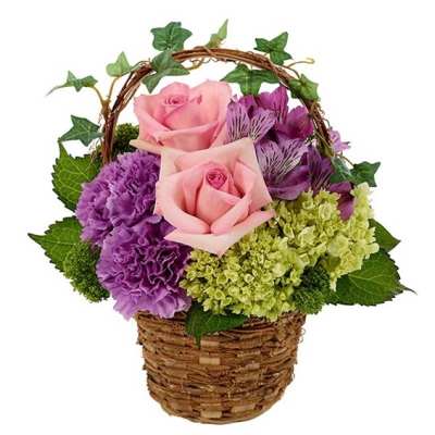 Pink roses and purple flowers in a wicker basket with ivy accents