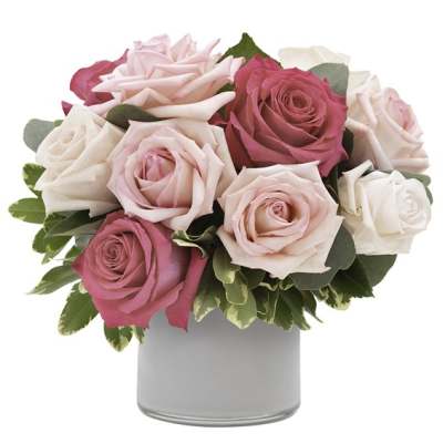 Pink and white roses arranged in a gray vase
