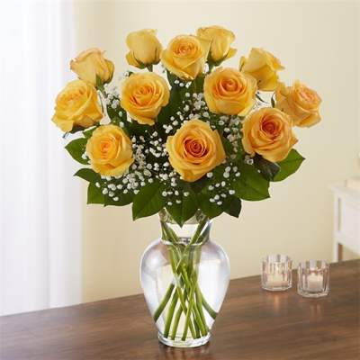 Yellow roses in a clear glass vase with baby's breath