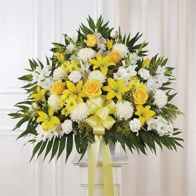Yellow and white floral arrangement with a ribbon bow in a vase