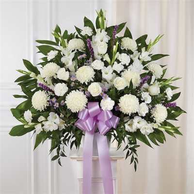 White floral standing spray with a lavender ribbon