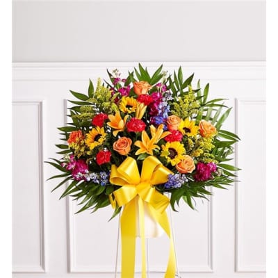 Colorful floral standing spray with a yellow ribbon bow