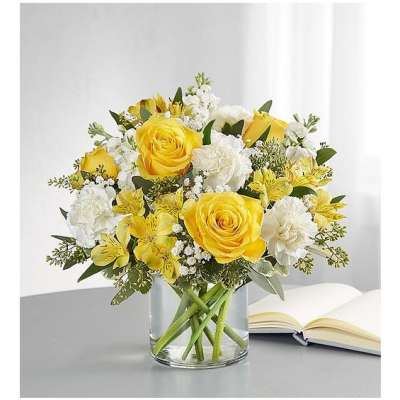 Yellow and white flower bouquet in a clear glass vase