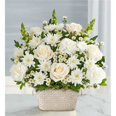 White roses and daisies arranged in a patterned basket
