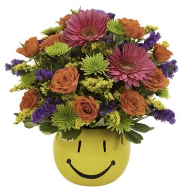 Bright mixed bouquet in a yellow smiley-face vase