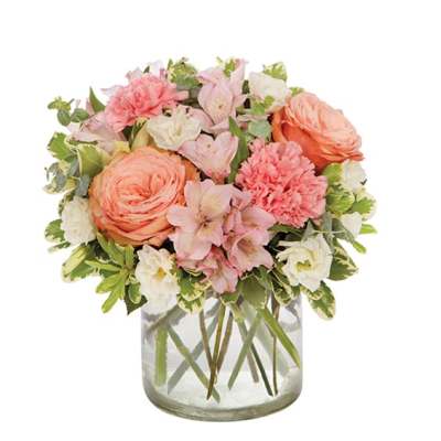 Pink and peach flowers arranged in a clear glass vase